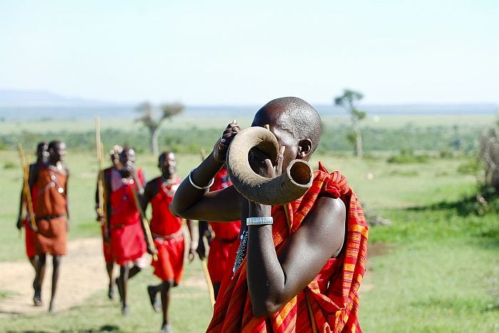 Masai man blowing horn