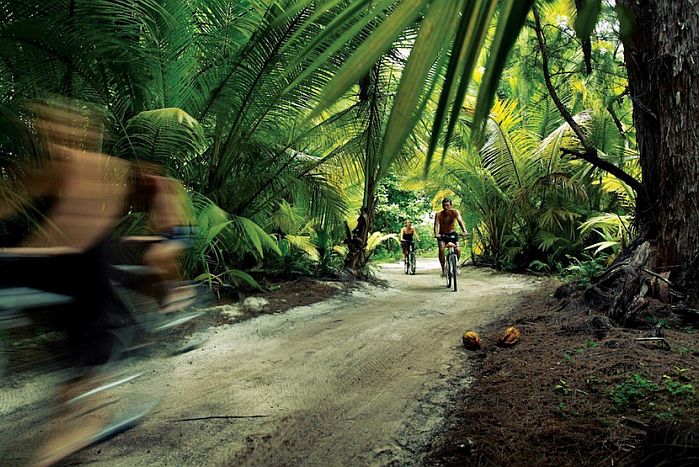 Cycling in forest on Desroches island, outer islands of Seychelles