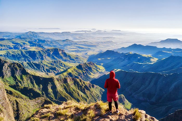 Man standing at top of Drakensberg Amphitheatre - where to visit in South Africa