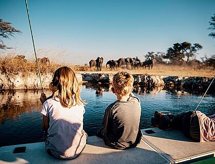 Namibia family safari - enjoying a boat cruise on Kwando river with elephants