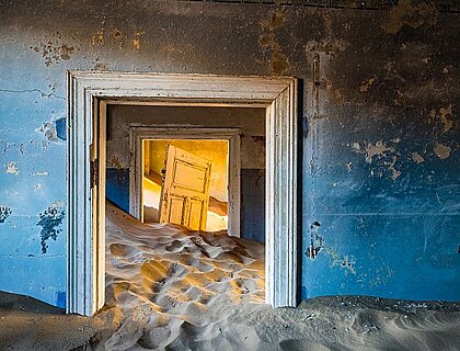 Southern Namibia - inside Kolmanskop, Sunsrise inside one of the abandoned mining houses of Kolmanskop, Namibia, which are covered in sand