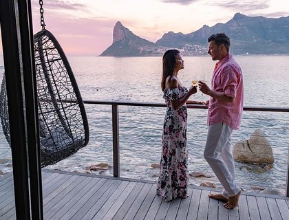 Honeymoon destinations in Africa - couple man and women drinking coffee during sunrise in Cape Town South Africa.